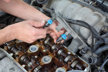 Mechanic fixing fuel injector, two camshaft car engine