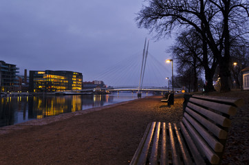Park bench at sidewalk along the river