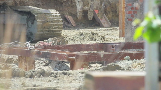Construction extravator diggin in the ground. People in the shot