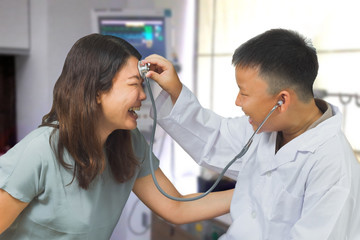 Fototapeta premium Boy acts like a doctor check up his mother