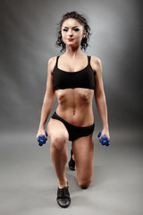 Fototapeta na wymiar Beautiful sporty woman lifting dumbbells
