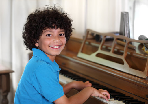 Young mixed race boy smiles while playing the piano