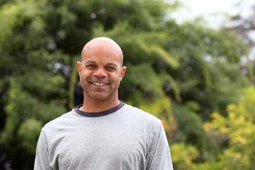 African american man poses outside in the park