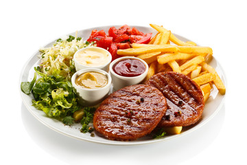 Grilled steaks, French fries and vegetables