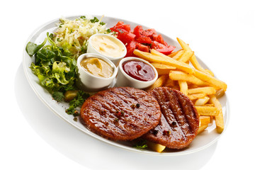 Grilled steaks, French fries and vegetables