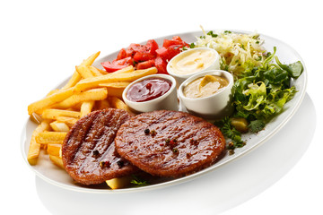 Grilled steaks, French fries and vegetables