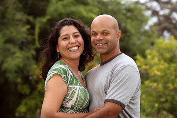 A happy mixed race couple relax outside