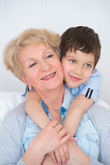 Lovely little boy with his grandmother having fun and happy mome