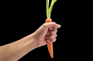 hand grabbing a carrot with black background