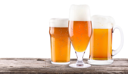 Frosty fresh beer  with foam isolated  on wooden table