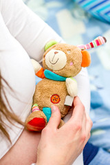 Teddybär in den Händen einer werdenden Mutter