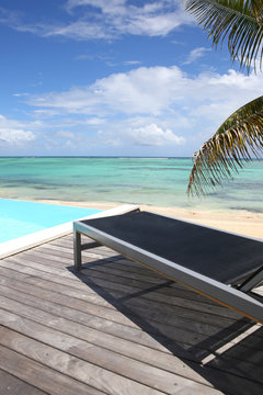 Infinity pool with deck chair by the beach