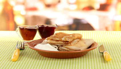 Pancakes with cottage cheese on plate on bright background