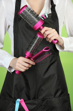 Hairdresser in uniform with working tools, on color background