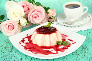Panna Cotta with raspberry sauce, on color wooden background