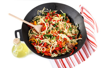 Noodles with vegetables on wok isolated on white