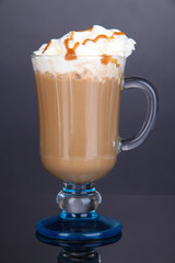 Layered coffee in glass on table on grey background