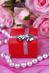 Rose and engagement ring on pink cloth