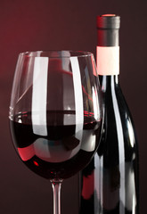 Wine in glass and wine bottle close-up on dark background