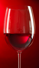 Glass of wine on red background