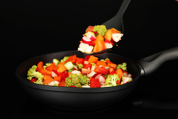 Vegetable ragout in pan, isolated on black
