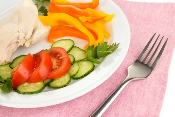 Boiled chicken breast on plate with vegetables close up