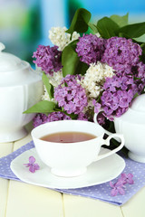 Composition with beautiful lilac flowers, tea service
