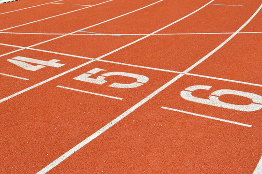 numbers on running tracks of outdoor athletic stadium © netsuthep