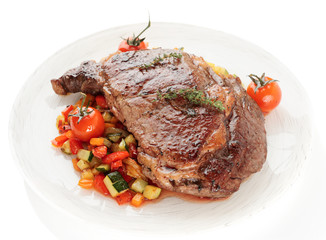 Ribeye steak with stir fried vegetables isolated on white