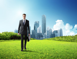 business man walking on green field and modern city