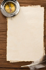 ink feather and compass on parchment background