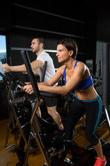 elliptical walker trainer man and woman at black gym