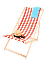 Studio shot of a sun lounger with towel, hat and sunglasses