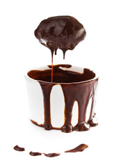 Cup of hot brown chocolate cocoa flow on white background, close