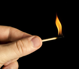 Hand holding burning match stick