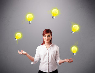 young lady standing and juggling with light bulbs