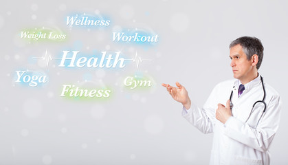 Clinical doctor pointing to health and fitness collection of wor