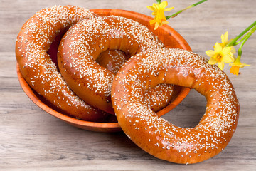 Baked bagels sprinkled with sesame seeds on wood table