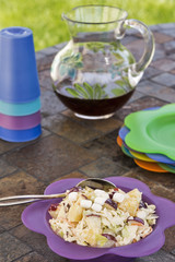 Coleslaw with a pitcher of iced tea at a picnic