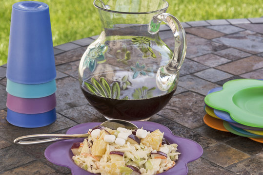 Coleslaw with a pitcher of iced tea at a picnic