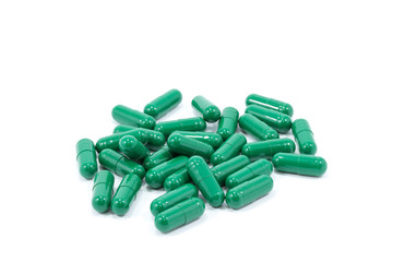 Green capsule pills on white background