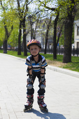 Cute young boy skater in spring park