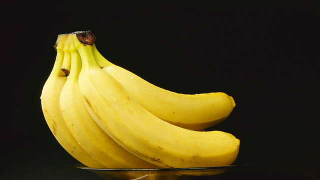 Bunch of bananas rotating on black background