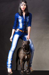 Beautiful woman in jeans clothes  standing next to a dog