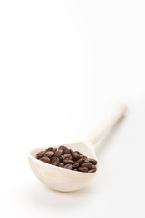 wooden spoon with coffee beans, isolated on white