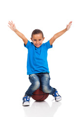 little girl sitting on a basketball ball