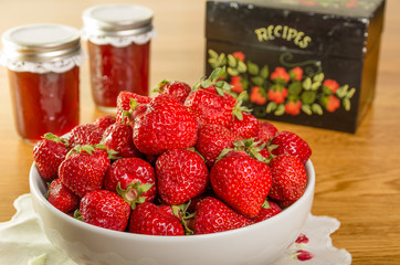 Bowl of strawberries and jars of jam