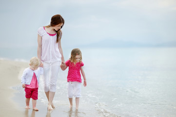 Mother and her kids walking along a beach