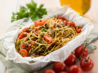 spaghetti with cherry tomatoes and green olives, selective focus