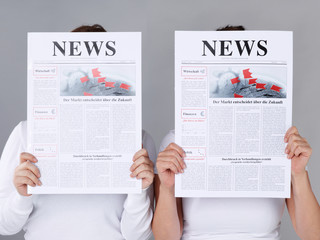 Two girls reading newspaper